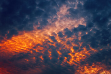Fire in the sky. Orange and dark blue clouds like flowing volcanic lava. Great abstract texture in bright colors for your design.