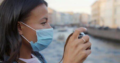 Close up of african female tourist with protective mask and camera on city street