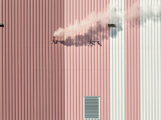 Cloud of smoke coming out of a pipe on a pink and white building - obrazy, fototapety, plakaty
