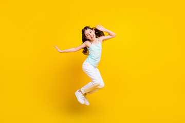 Fototapeta na wymiar Full length body size view of pretty cheerful girl jumping having fun good mood isolated over bright yellow color background