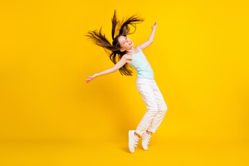 Fototapeta na wymiar Full body profile side photo of active funky little girl fly hair good mood isolated on yellow color background
