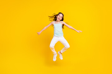 Fototapeta na wymiar Full body photo of active energetic happy small girl jump up crazy excited isolated on yellow color background