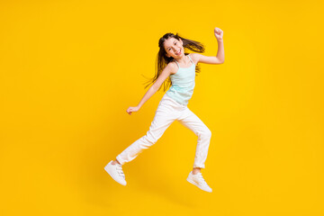 Fototapeta na wymiar Full size photo of happy cute little girl jump up good mood weekend rest isolated on yellow color background