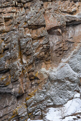 Rocky surface in winter for a backdrop. Sharp ledges, white snow. Concept of winter season in mountains.