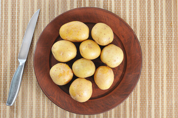 young potatoes in the peel on a clay plate