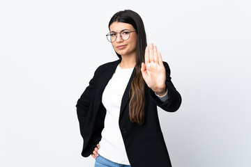 Business woman over isolated white background making stop gesture with her hand