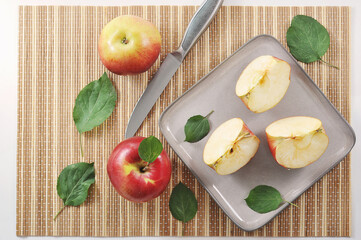 ripe red apples and cut into slices with green leaf and gray knife