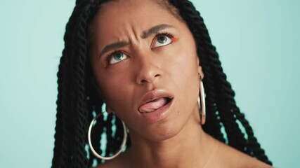 A close-up view of a cheerful african woman showing different facial emotions isolated over a blue background in the studio