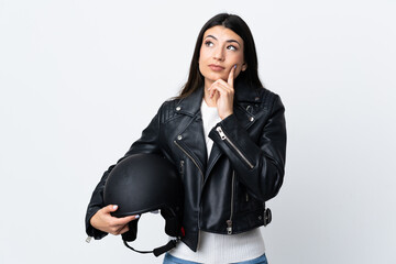 Young woman holding a motorcycle helmet over isolated white background thinking an idea