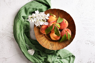 Top view of fresh peaches in metal bowl on the table
