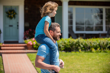 happy father carry son near house. family value. childhood and parenthood.