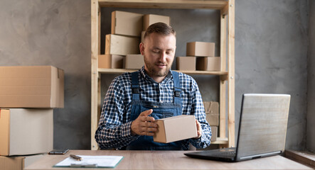 business man checking product and orders on laptop, with carton packaging, online sales with start-up and small business