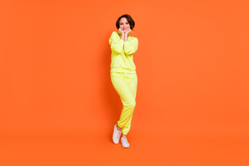 Fototapeta na wymiar Full length body size view of attractive shy cheerful girl posing good mood isolated over bright orange color background