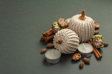 Autumn composition with crocheted pumpkins, candles, spices, and traditional decor