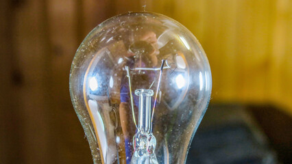 Old incandescent light bulb in hand