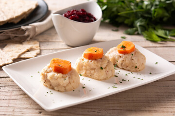 Traditional Jewish gefilte fish with beetroot and matzah bread on wooden table