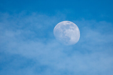 Obraz na płótnie Canvas almost full moon over blue sky