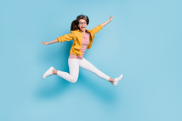 Fototapeta na wymiar Full length profile side photo of young woman happy positive smile fly air hands wings jump isolated over blue color background