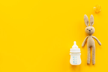 Child toy knitted rabbit with milk bottle, overhead view