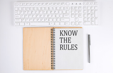 KNOW THE RULES text on the notebook with keyboard on white background