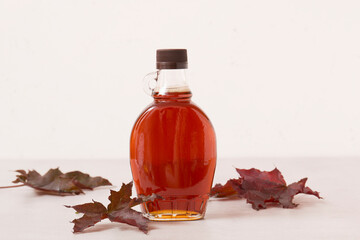 Beautiful maple syrup in a bottle. Maple leaves
