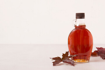 Beautiful maple syrup in a bottle. Maple leaves
