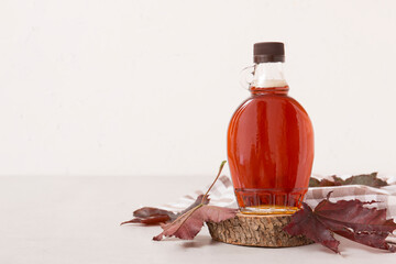 Beautiful maple syrup in a bottle. Maple leaves
