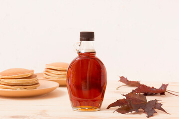 Beautiful maple syrup in a bottle. Maple leaves
