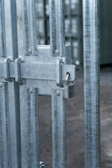 Security gate entrance locked with a padlock and sliding bolt