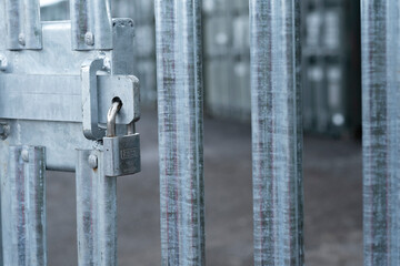 Security gate entrance locked with a padlock and sliding bolt