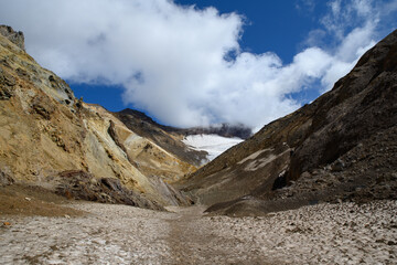 The gorge of the Mutnovsky volcano with a glacier and a path along which the ascent takes place
