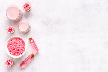 Flat lay of pink roses cosmetic with aroma oil and liquid for skin care