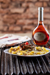 Spaghetti pasta with tomato sauce, meat, mozzarella cheese and fresh basil in deep white dish, red...