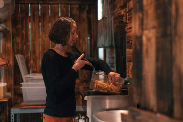 cheerful young woman working in a fish and chips kiosk frying french fries