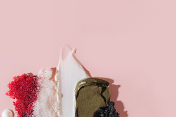Various cosmetic mask, creams, serum, scrub and lotion smear on a pink background. Beauty texture....