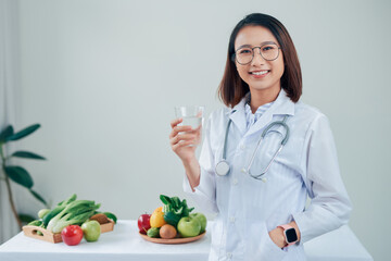 Female nutritionist showing milk glass at her office.