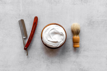 Brush foam shaver and shaving foam in wooden bowl, top view