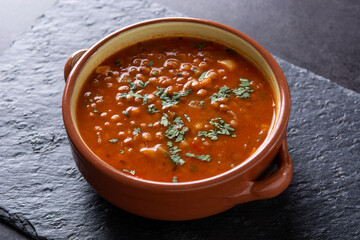 Red lentil soup in bowl on black stone