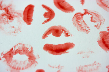 Set of sexy pink red female lip prints on white paper background top view. Kisses flatly. Lipstick prints, marks. Femininity, flirt, love concept. World Kissing Day. Valentine's Day. Lovely backdrop.