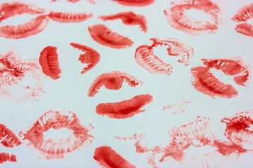Set of sexy pink red female lip prints on white paper background top view. Kisses flatly. Lipstick prints, marks. Femininity, flirt, love concept. World Kissing Day. Valentine's Day. Lovely backdrop.