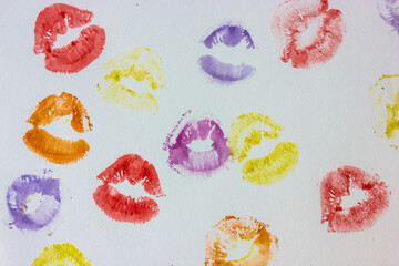 Set of multicolored female lip prints on white paper background top view. Kisses flatly. Lipstick prints, marks. Femininity, flirt, love concept. World Kissing Day. Valentine's Day. Lovely backdrop.