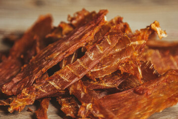 delicious jerky on a wooden background. products in craft packaging. snack for alcohol. macro photo. close-up.