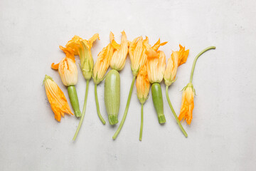 Fresh yellow zucchini flowers on a light background. A lot of zucchini on a light background.
