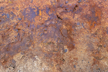 Textured concrete wall for backdrop. Brown rusty coating, pebbles, irregularities.