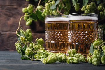 Two mugs of beer on the wooden table background.