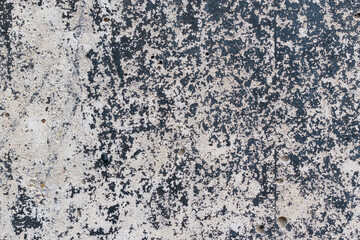 Textured concrete wall for backdrop. Patterned black paint residues. Caverns in surface.
