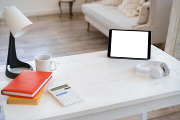 White working table with blank screen digital tablet