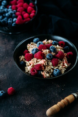 Oatmeal with raspberries and blueberries in a black plate