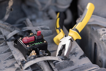 Car audio system circuit breaker and work tools close up background.