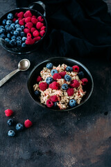 Oatmeal with raspberries and blueberries in a black plate